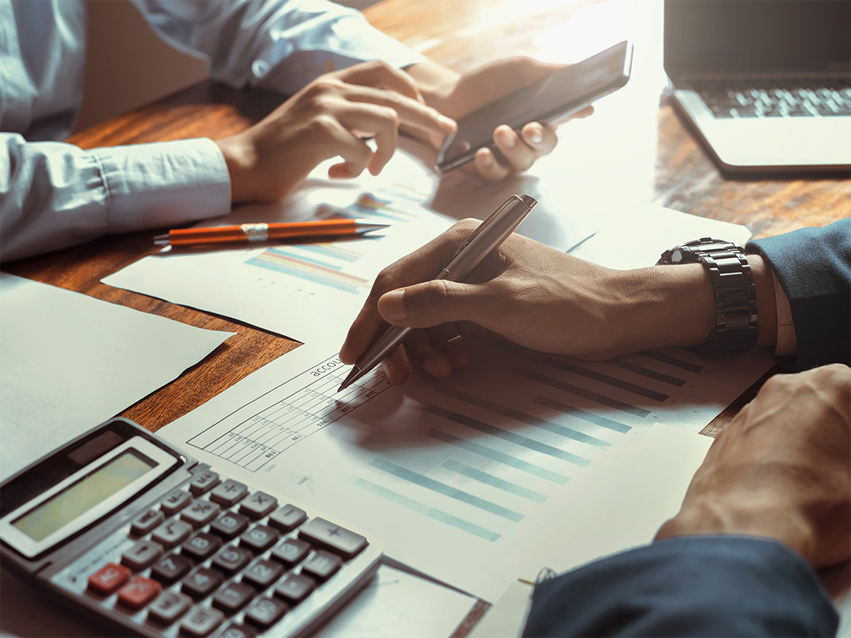 investment concept - two people with paperwork making calculations